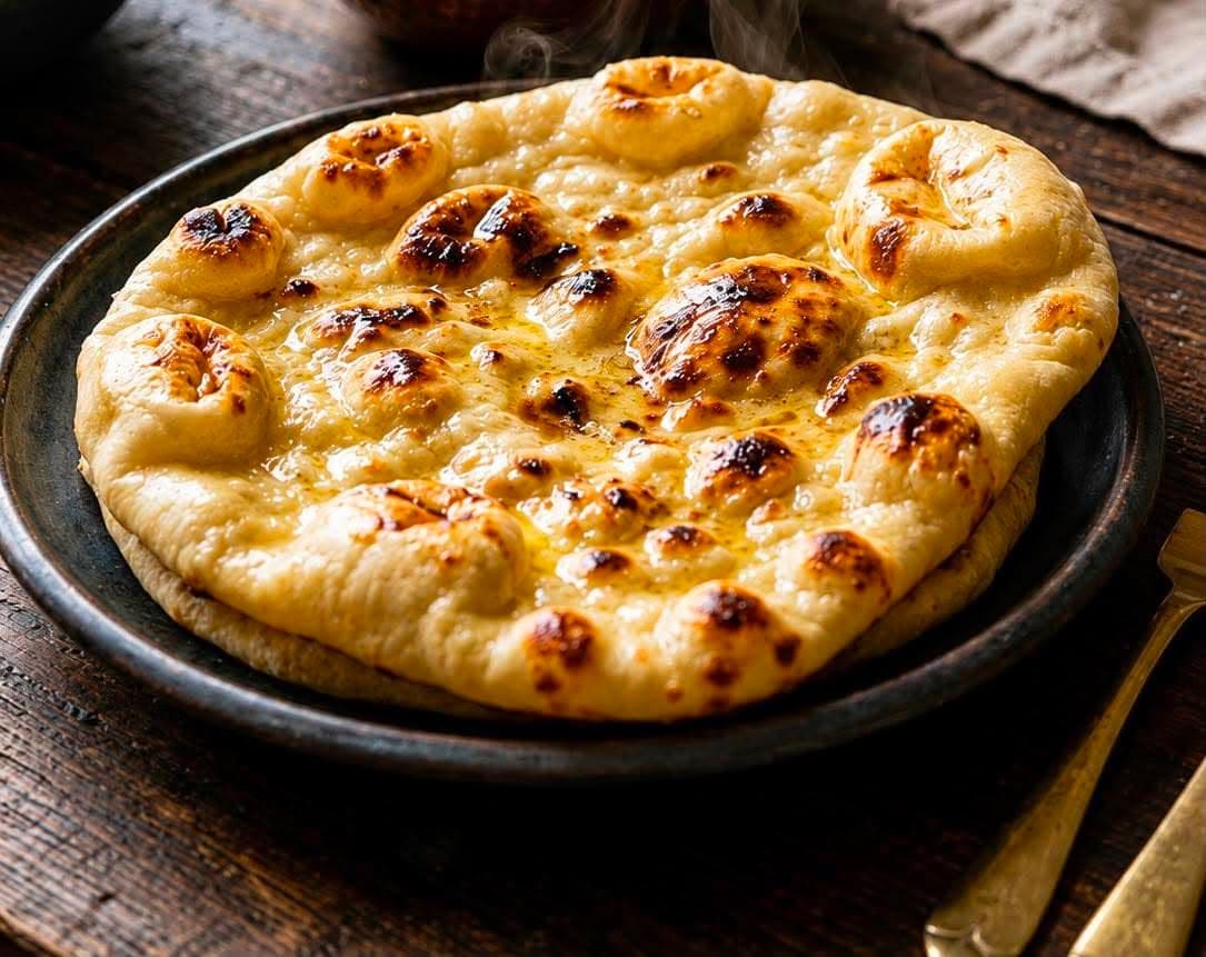 Butter Naan — Classic naan bread filled with butter, baked in the clay oven.