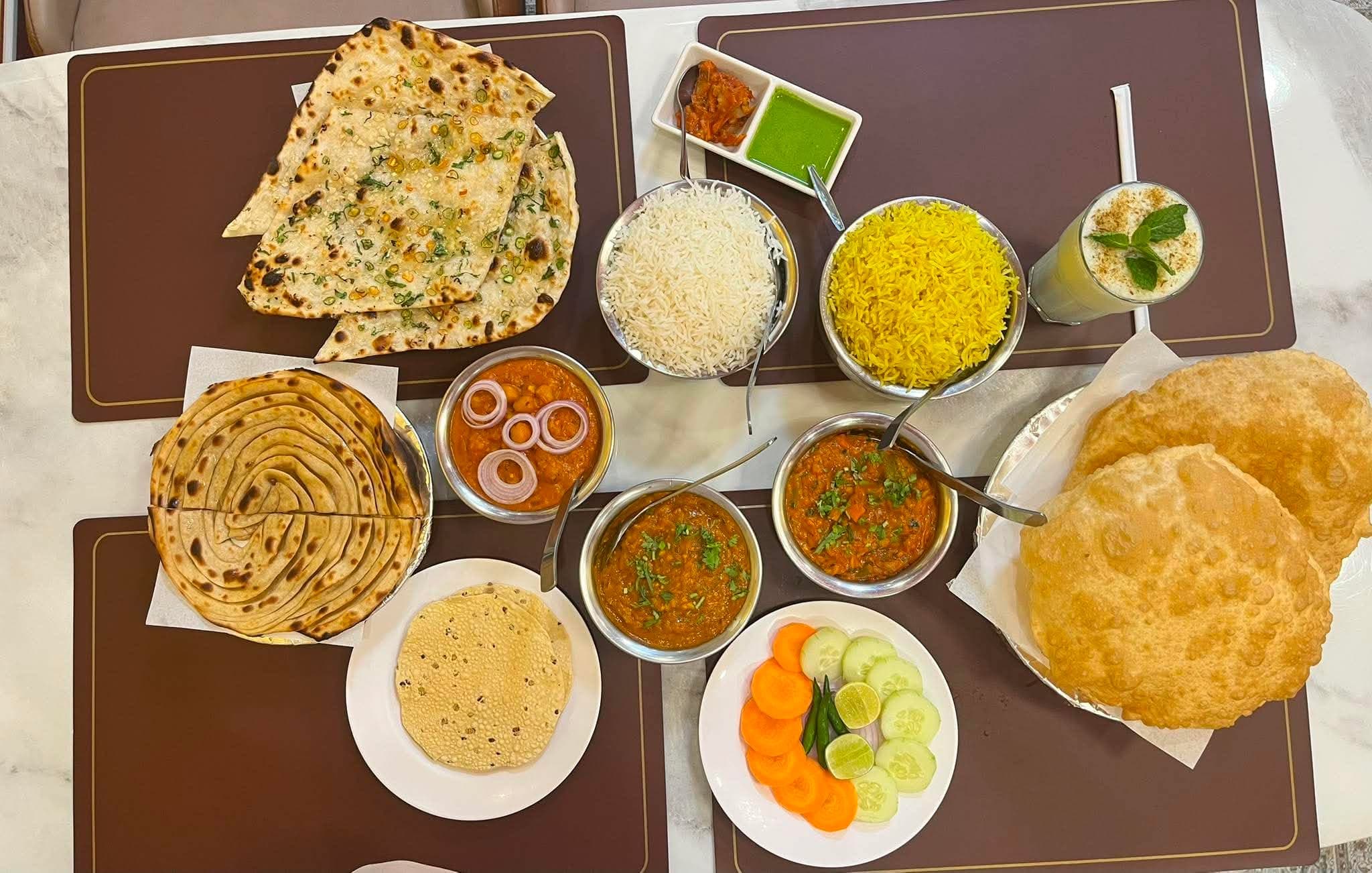 A full Indian thali spread — naan, rice, curries, papad, salad and lassi at Indian Flavours Indian Food