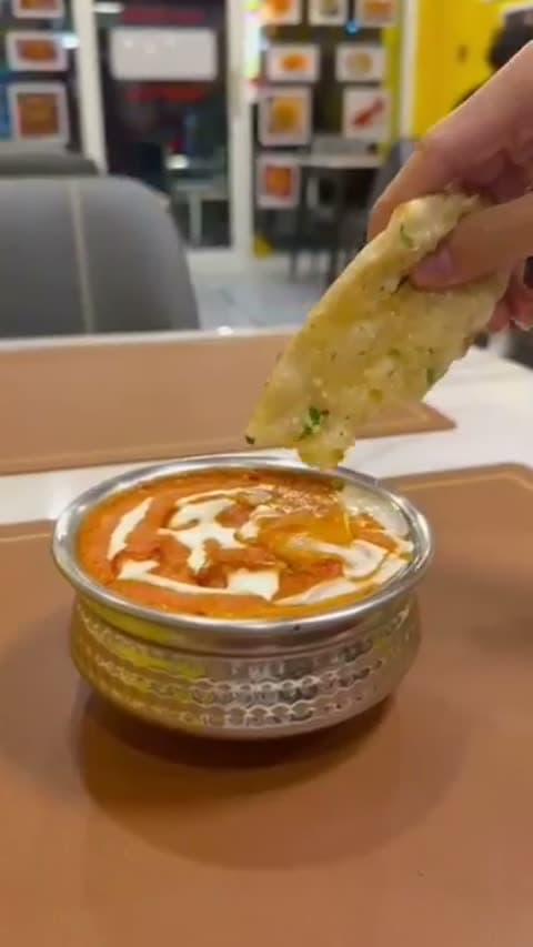 Enjoying naan and curry by the storefront window