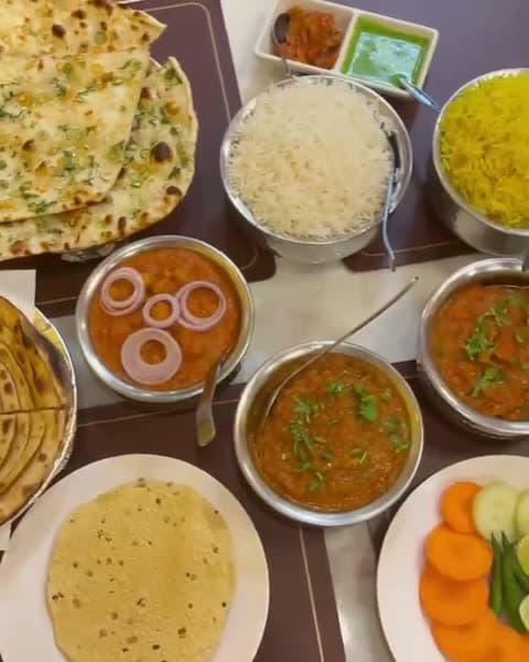 A full table spread of curries, naan, and rice